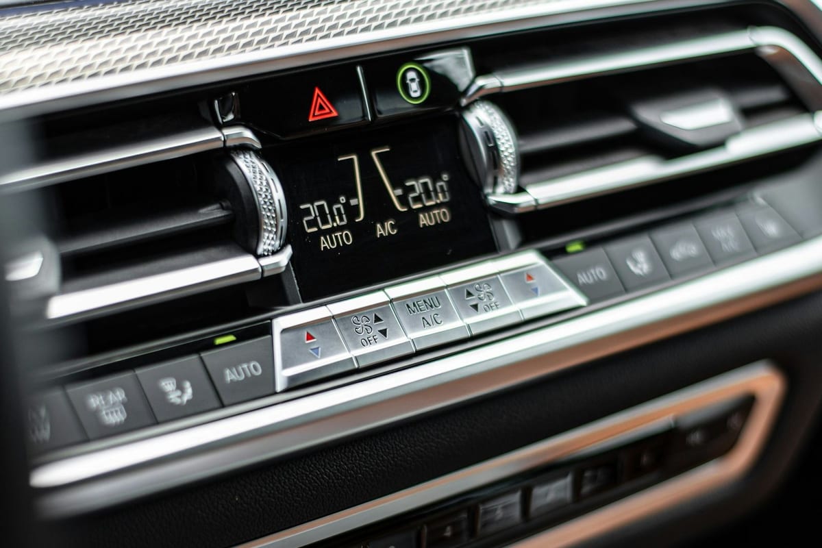 The quiet interior of a parked car: dashboard, steering wheel, and empty seats in soft daylight.